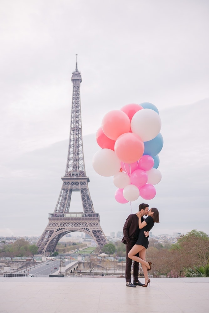 Crazy couples pictures  Young couple kissing underneath huge and colorful balloons in Paris